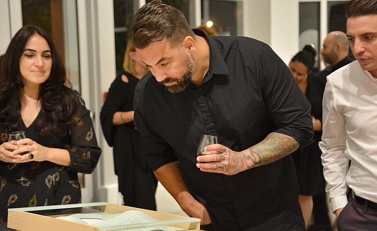 Guest intently looking at an art piece tray at our event “benefit!” that had designers reinterpreting our bulthaup trays for an evening of silent auction and good food all in support of the non-profit Common Threads.
